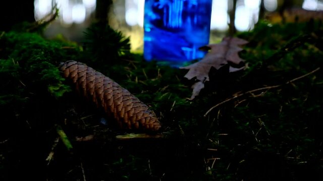 Magical blue smoking potion. herbal potion. Herbal elixir on a mossy stump on a blurred forest background.Magic Potion. Homeopathic medicine. 