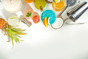 Colorful summer drinks set. Various bright alcohol cocktails and beverages, in different glasses, with tropical fruit on white background copy space
