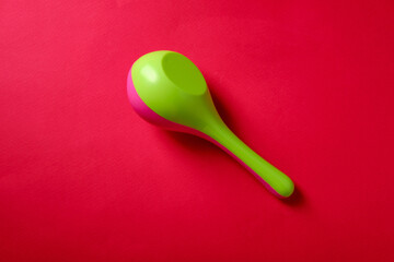 Baby rattle on a red background, top view