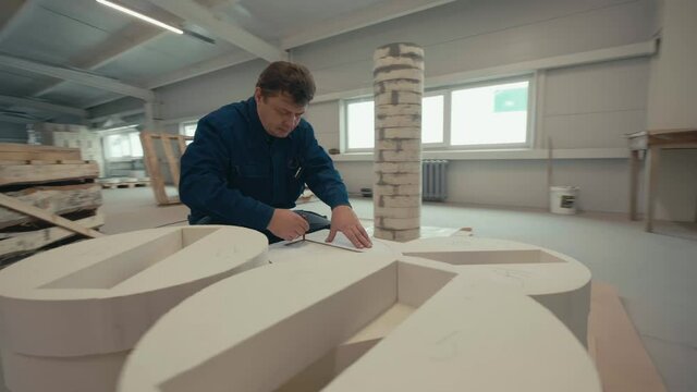 Asbestos Board Factory. Worker is Using the Stencil with the Rectangle Shape. He is Outlining the Inside Shape with a Red Pen. Then Outlining the Outside of the Stencil. Production Process.Slow motion