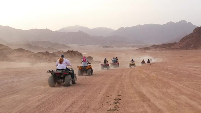 Quad bike ride through the desert near Sharm el Sheikh, Egypt.Adventures of desert off-road on ATV.Sand and Sand Borkhan. Rock and sunset. Quad Cycle Travel. Excursion with people.