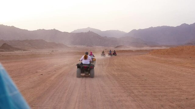 Quad bike ride through the desert near Sharm el Sheikh, Egypt.Adventures of desert off-road on ATV.Sand and Sand Borkhan. Rock and sunset. Quad Cycle Travel. Excursion with people.