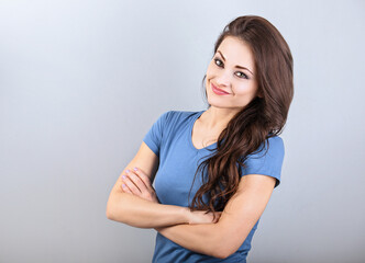 Fototapeta premium Beautiful young casual cute smiling woman thinking with folded arms. Closeup portrait with empty copy space
