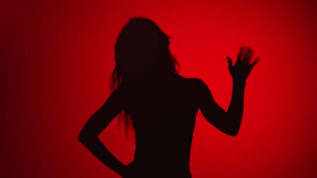 Black shadow portrait woman waving hand hello or goodbye isolated on red. Shot with RED camera in 4K
