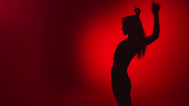 Dark shadow of woman go go dancer performing dance show on red slowmo. Shot with RED camera in 4K