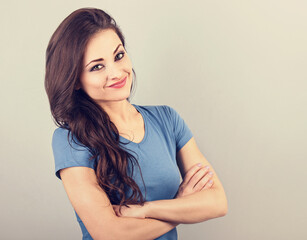 Fototapeta premium Beautiful young casual cute smiling woman thinking with folded arms. Closeup portrait with empty copy space