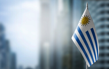 A small flag of Uruguay on the background of a blurred background - obrazy, fototapety, plakaty