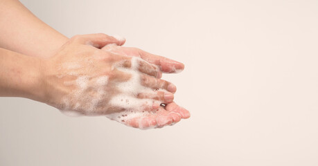 Hands washing gesture with foaming hand soap on white background.