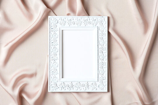Chic style photo frame with empty space for text on silk fabric. Flat lay, top view, copy space.