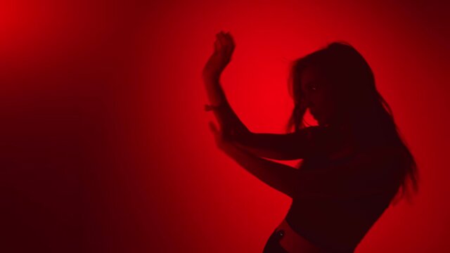 Dark shadow of dancer woman waving hands performing wave choreography. Medium shot on RED camera