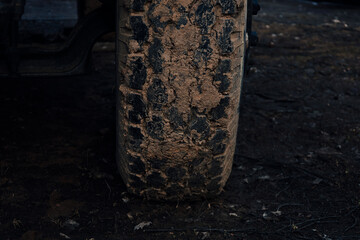 Fototapeta na wymiar Detail of a off-road tire covered with mud. Close up of dirty car wheel with rubber tire covered with yellow mud. 