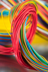 Swirl of colorful electrical and telecommunication cable on shiny metal surface