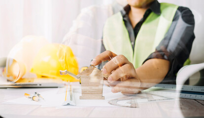 Two colleagues discussing data working and tablet, laptop with on on architectural project at construction site at desk in office
