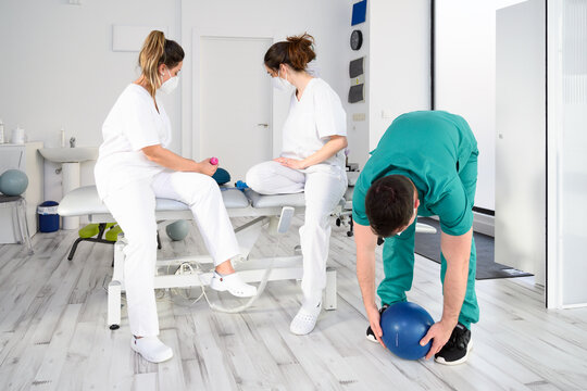Diverse team of healthcare professionals wearing protective face mask, working at a physical rehabilitation clinic during coronavirus pandemic. High quality photo - Powered by Adobe