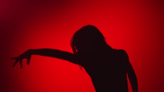Black shadow of flexible dancer lady performing dance movement. Medium shot on RED camera