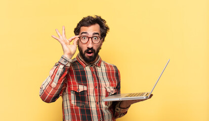 young crazy bearded man surprised expression and a laptop