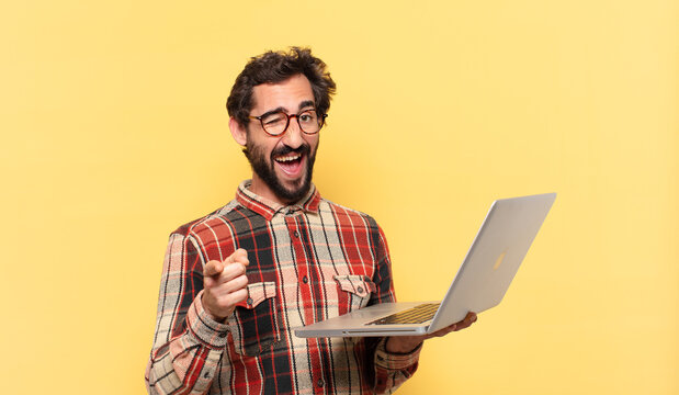 young crazy bearded man pointing or showing and a laptop