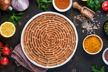 Set of Indian fragrant spices and herbs on a black stone background. Turmeric, dill, paprika, cinnamon, saffron, basil and rosemary in a spoon. Top view. Mock up.