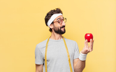 young crazy bearded athlete thinking expression and holding an apple and holding an apple