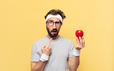 young crazy bearded athlete sad expression and holding an apple and holding an apple