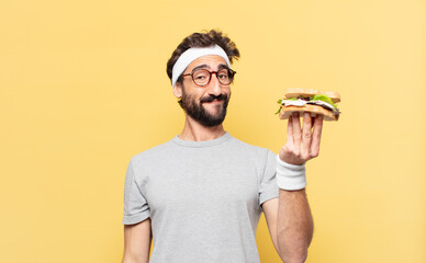 young crazy bearded athlete happy expression and holding a sandwich