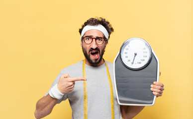 young crazy bearded athlete angry expression and holding a scale