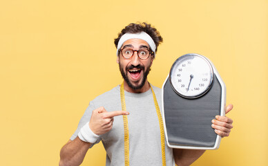 young crazy bearded athlete surprised expression and holding a scale