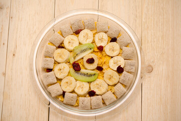 healthy breakfast on a plate cornflakes with kiwi bananas and cranberries