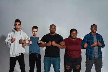 Multiracial people holding hands under each other elbows