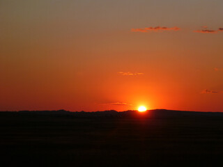 Scenic view of a sunset with bright red and orange glow at Badlands National Park in South Dakota