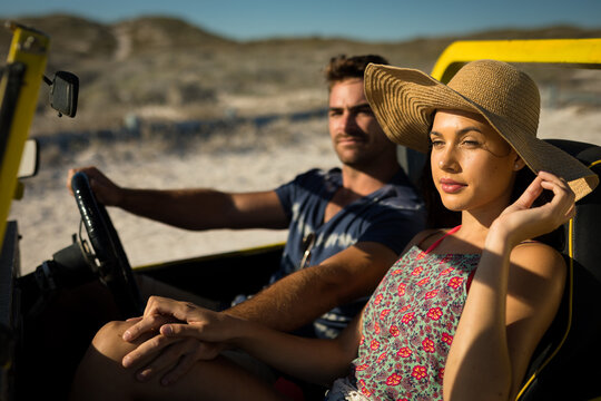 Happy caucasian couple sitting in beach buggy by the sea holding hands - Powered by Adobe