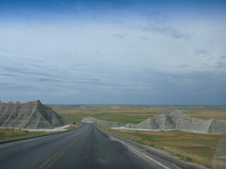 A road going through the surreal landscape and terrain at Badlands National Park in South Dakota