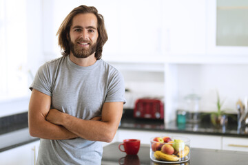 Portrait of caucasian man in kitchen smiling with arms crossed