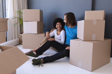 Happy diverse couple moving house sitting and embracing