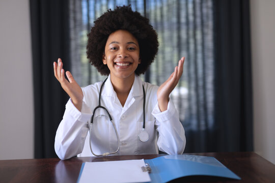 African American Female Doctor Sitting Making Video Call Consultation