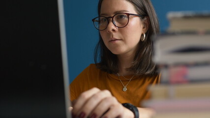 girl specialist in decoration issues surfs information on Internet to create sketch sitting at workplace closeup