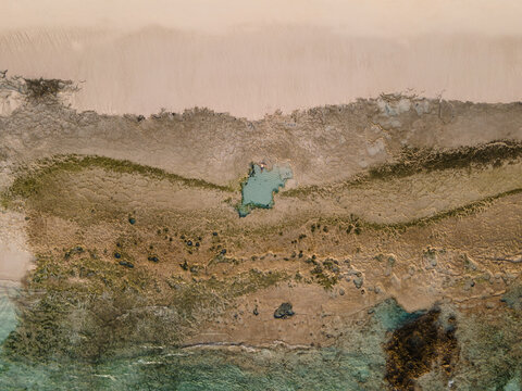 Man Lying On The Edge Of A Natural Pool On The Beach Shore Top View Aerial Shot. Fuerteventura, Canary Islands