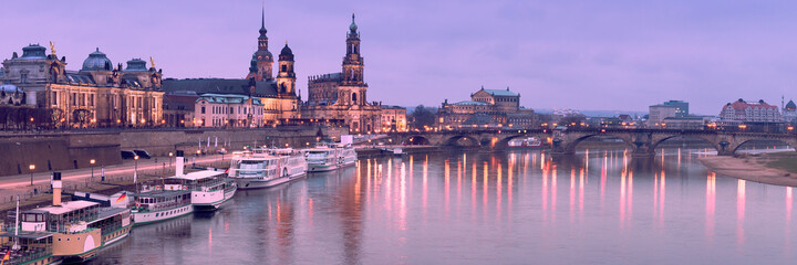Night panorama of Dresden Old town with reflections in Elbe river and passenger ships