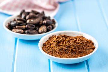 Roasted cocoa beans and cocoa powder in bowl