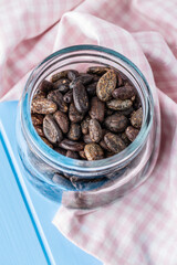 Roasted cocoa beans in jar.