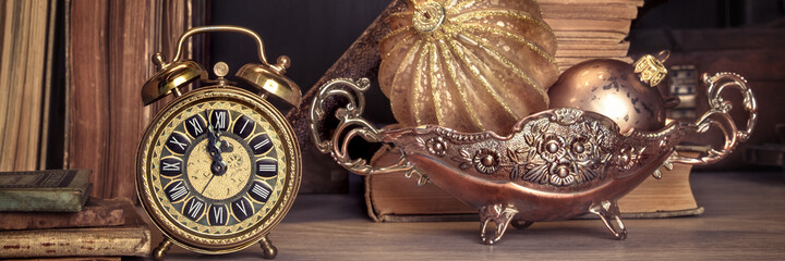 Vintage alarm clock showing five to twelve on wood, text space