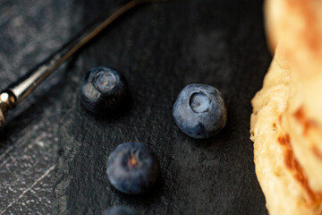 Stack of blueberry pancakes with syrup and fresh blueberries