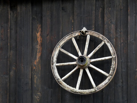 Wheel of an old cart on the wall of the antique house