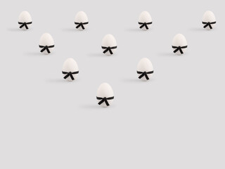 Creative funny Easter composition with eggs wearing black karate belt