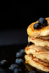 Stack of blueberry pancakes with syrup and fresh blueberries