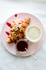 Cup of coffee, croissant and jam