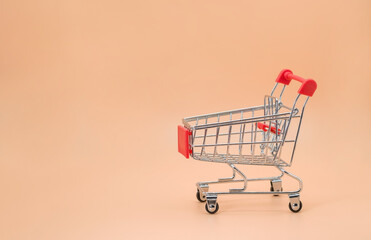 shopping cart empty with copy space on beige background