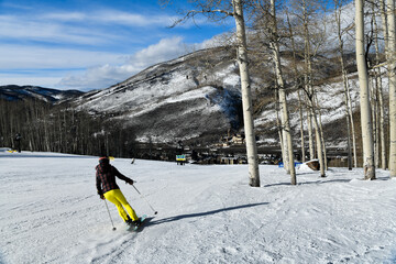 Back view of a woman skiing down the slope in Vail Colorado, USA