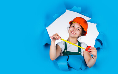 cheerful child laborer using building uniform and tape measure, copy space, labor day
