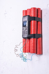 Fototapeta na wymiar Dynamite with a remote fuse hung on a white wall. An explosive charge in an apartment building.